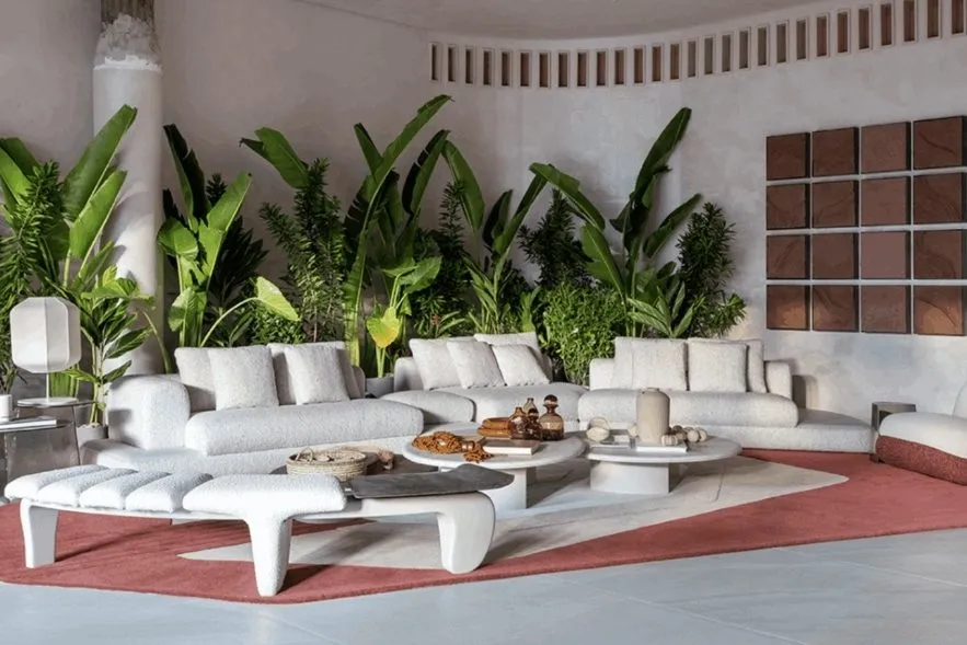 Sala ampla com sofás brancos e muitas folhagens, exemplo de ambiente biofílico apresentado na Casa Cor.